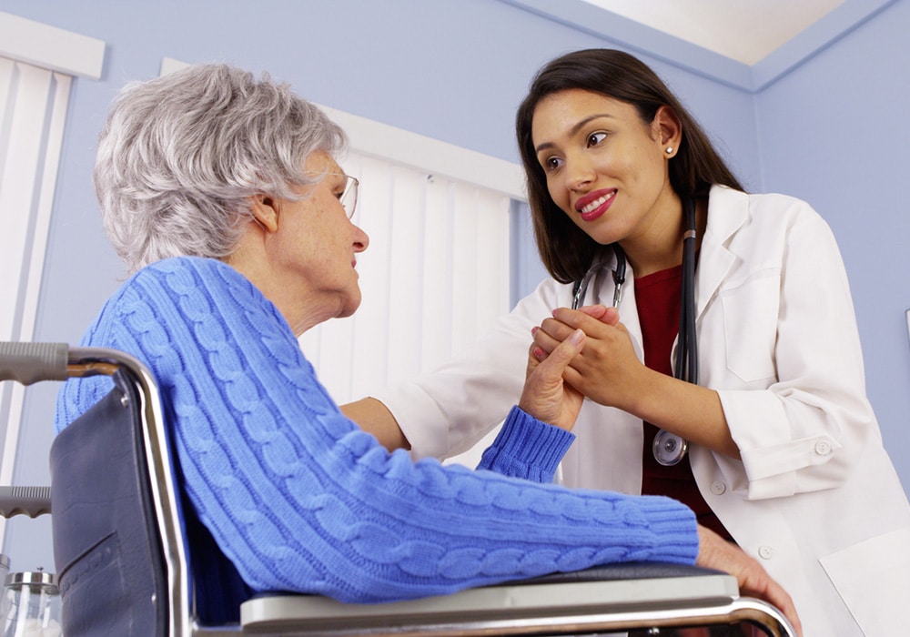 Doctor talking to woman in wheelchair